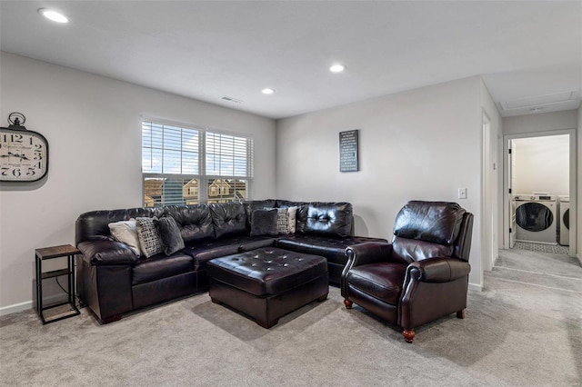 carpeted living room featuring washer and clothes dryer