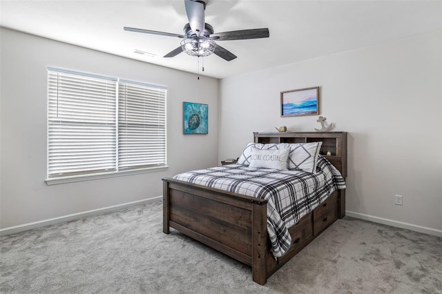 bedroom featuring ceiling fan, light colored carpet, and multiple windows