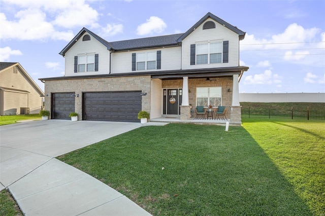 view of front of house featuring a garage, a front yard, and covered porch