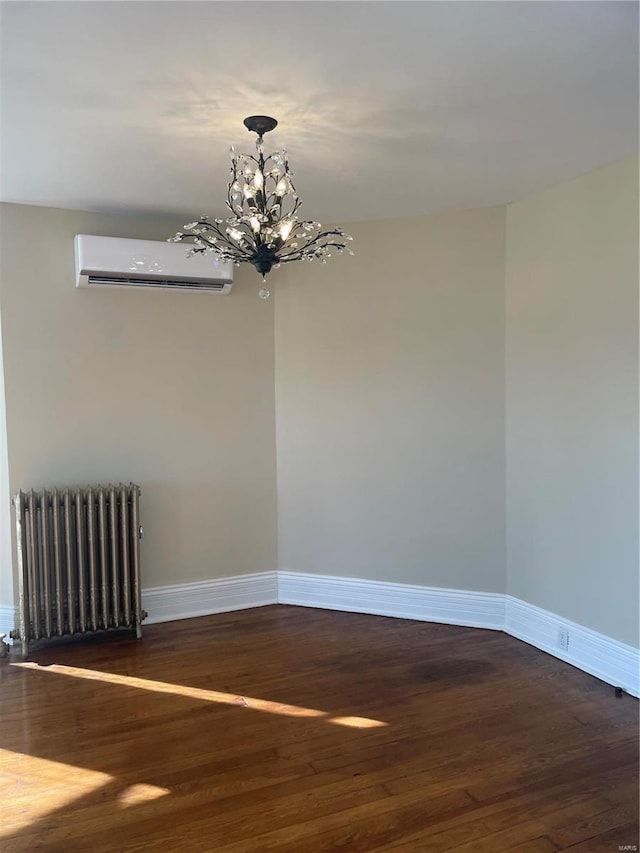 spare room featuring a wall mounted air conditioner, a chandelier, radiator heating unit, and dark hardwood / wood-style flooring