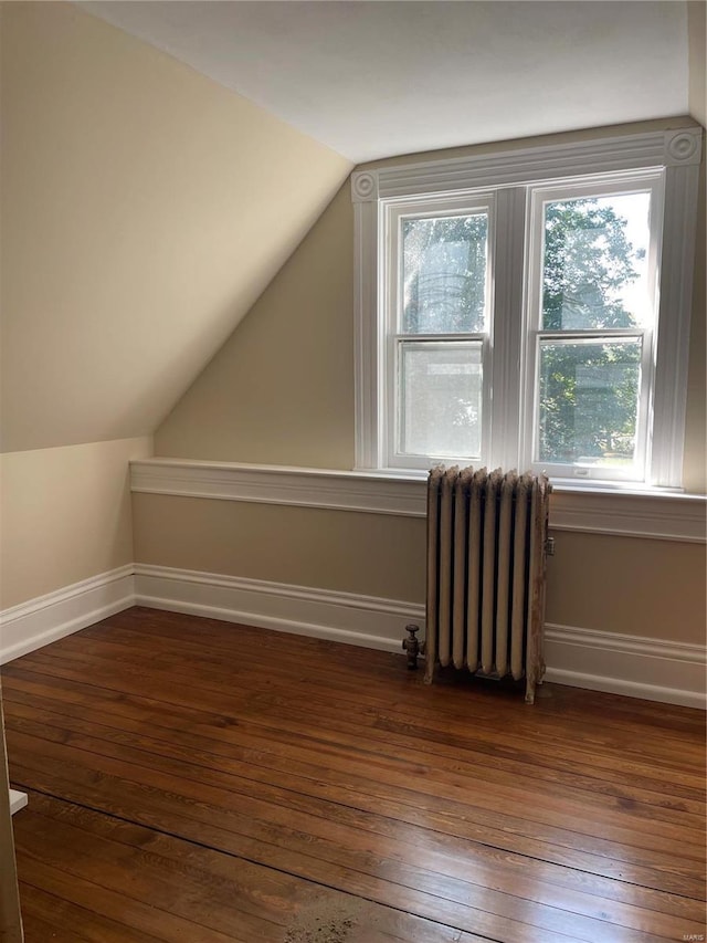 bonus room with radiator heating unit, dark hardwood / wood-style floors, and a healthy amount of sunlight