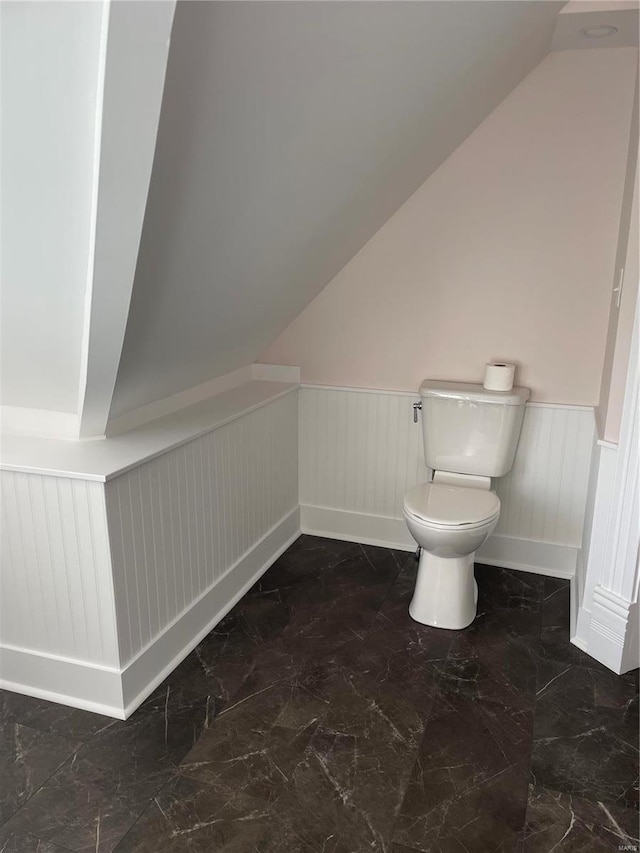 bathroom featuring lofted ceiling and toilet