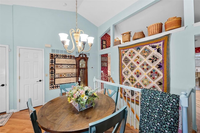 dining area featuring lofted ceiling, a notable chandelier, and light hardwood / wood-style flooring