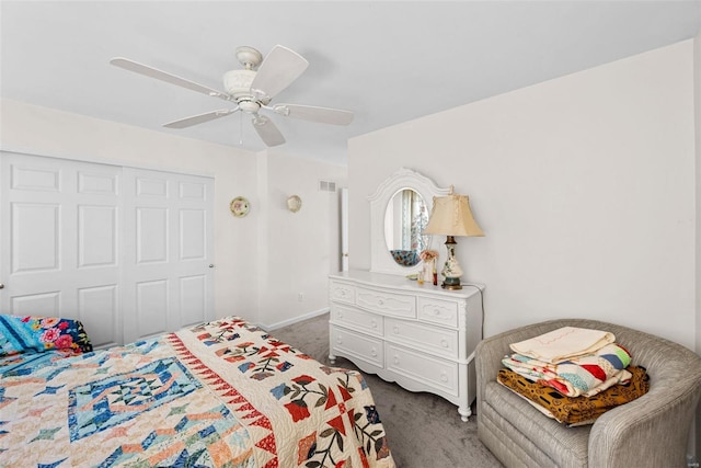 bedroom with ceiling fan, dark carpet, and a closet