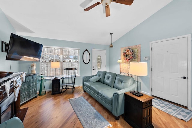 living room with lofted ceiling, ceiling fan, and light hardwood / wood-style flooring