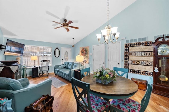 dining space featuring high vaulted ceiling, ceiling fan with notable chandelier, and light hardwood / wood-style floors