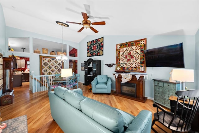 living room with hardwood / wood-style flooring, lofted ceiling, and ceiling fan with notable chandelier