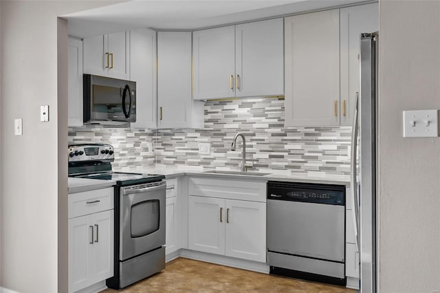 kitchen with stainless steel appliances, sink, white cabinets, and decorative backsplash