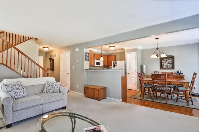 carpeted living room with a notable chandelier and crown molding