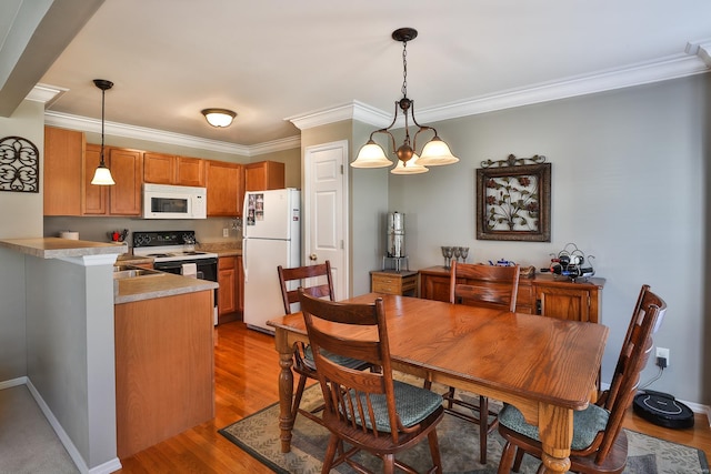 dining room with crown molding, dark wood-type flooring, and an inviting chandelier