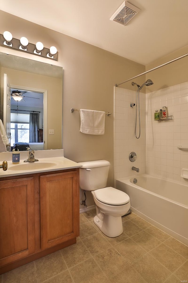 full bathroom with tiled shower / bath, vanity, toilet, and tile patterned floors