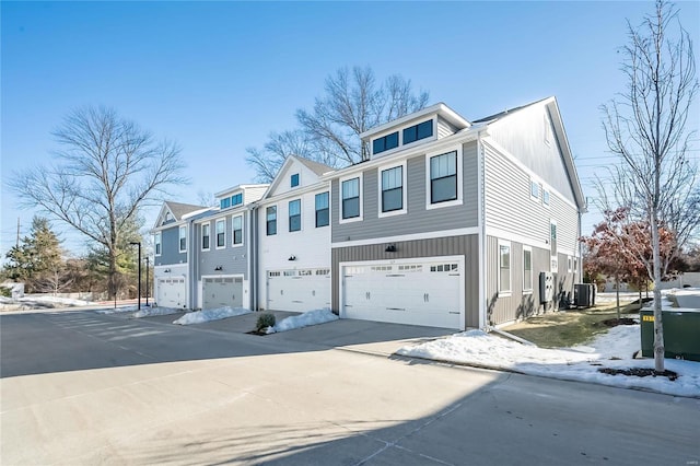 townhome / multi-family property featuring central AC and a garage