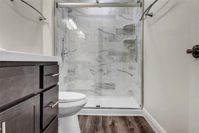 bathroom with walk in shower, toilet, and hardwood / wood-style flooring