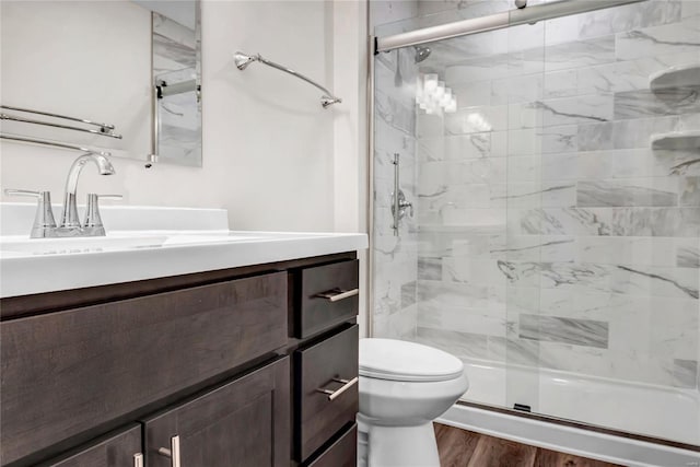 bathroom featuring vanity, toilet, an enclosed shower, and hardwood / wood-style floors