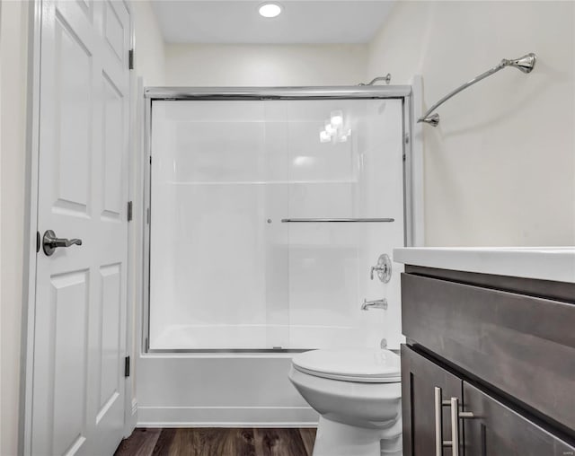 full bathroom with vanity, toilet, hardwood / wood-style floors, and combined bath / shower with glass door