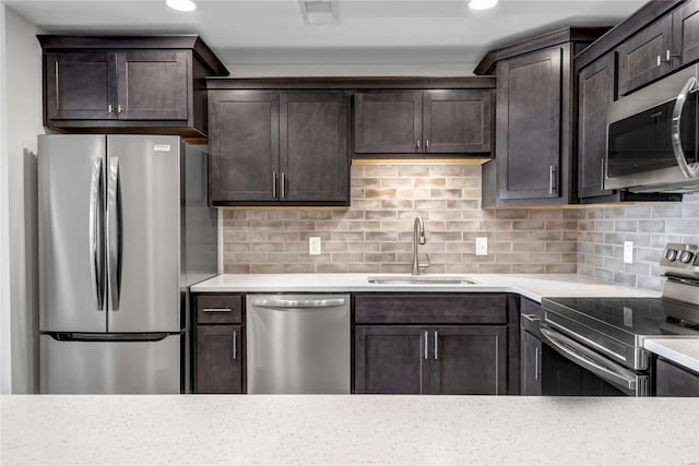 kitchen with tasteful backsplash, dark brown cabinetry, appliances with stainless steel finishes, and sink