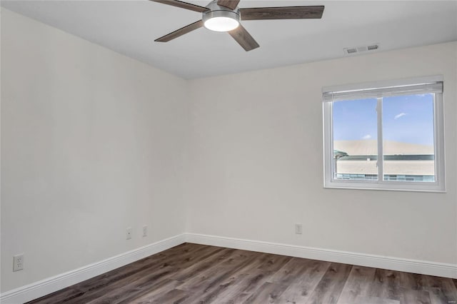 empty room featuring dark wood-type flooring, ceiling fan, and a water view