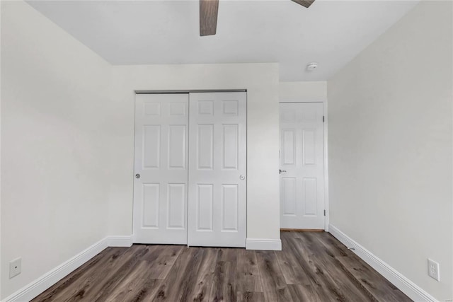 unfurnished bedroom with dark hardwood / wood-style floors, ceiling fan, and a closet