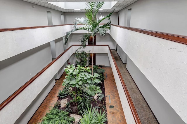 staircase with a skylight and a paneled ceiling