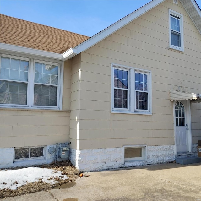 view of side of home featuring roof with shingles