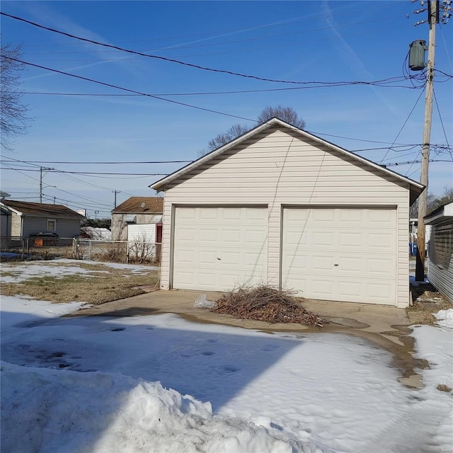 snow covered garage with a detached garage