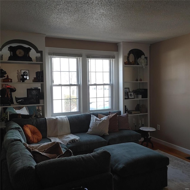 living room with wood-type flooring and a textured ceiling