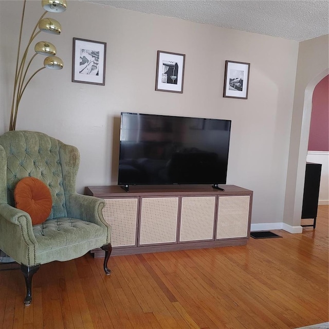 living area featuring hardwood / wood-style floors and a textured ceiling