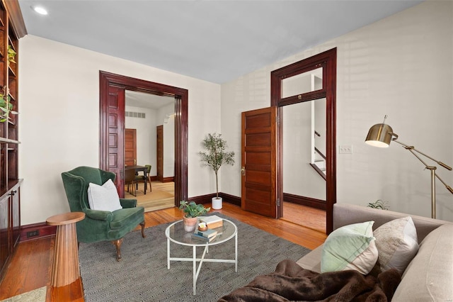 living room featuring hardwood / wood-style flooring and vaulted ceiling