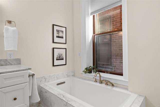 bathroom featuring vanity and tiled bath