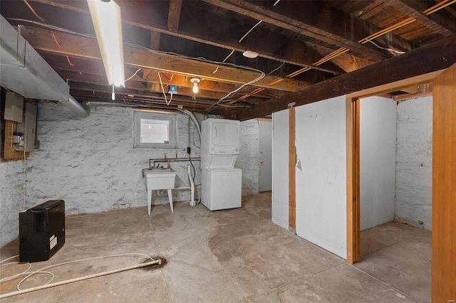 basement with stacked washer and clothes dryer and sink