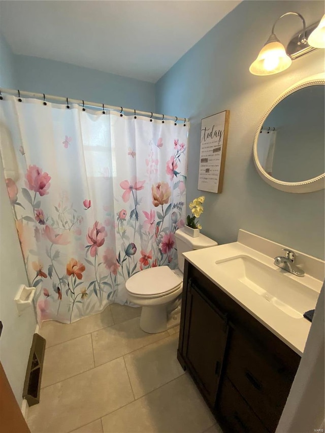 bathroom featuring vanity, tile patterned floors, and toilet