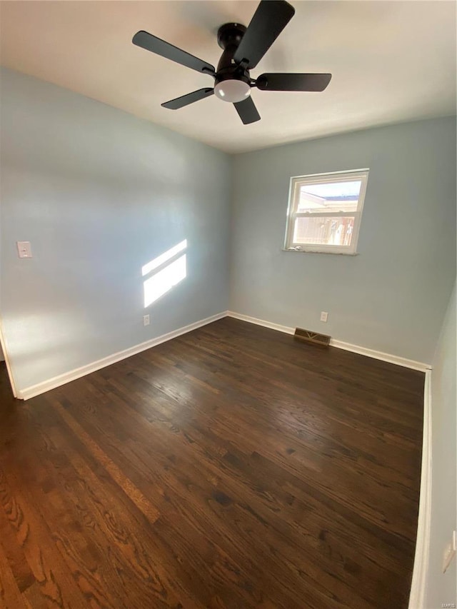 empty room featuring dark wood-type flooring and ceiling fan