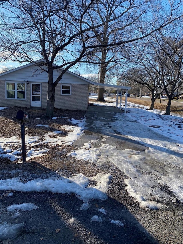 snow covered property featuring a carport