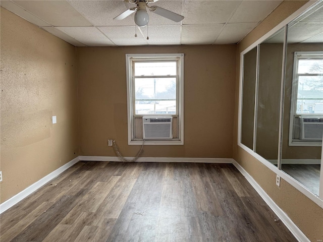 spare room featuring dark hardwood / wood-style flooring, cooling unit, a paneled ceiling, and ceiling fan