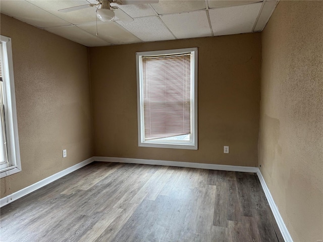 unfurnished room featuring wood-type flooring, a paneled ceiling, and ceiling fan