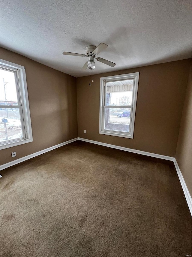 carpeted empty room featuring ceiling fan and a textured ceiling