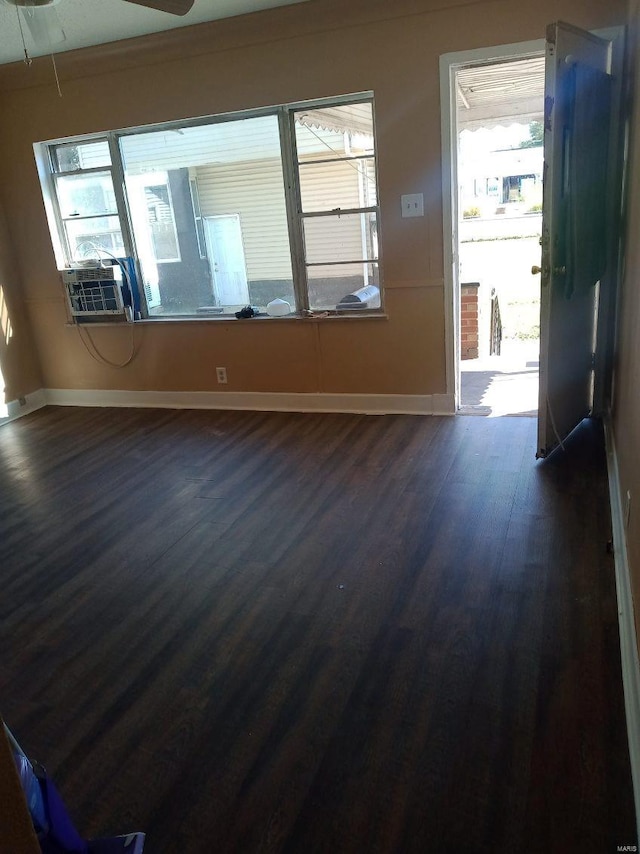 spare room with dark wood-type flooring, ceiling fan, and cooling unit