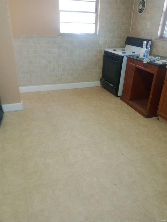 interior space with tile walls and range with electric stovetop