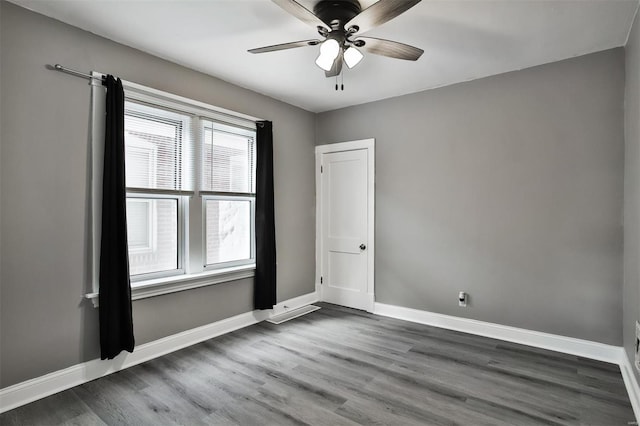 spare room with dark hardwood / wood-style floors and ceiling fan