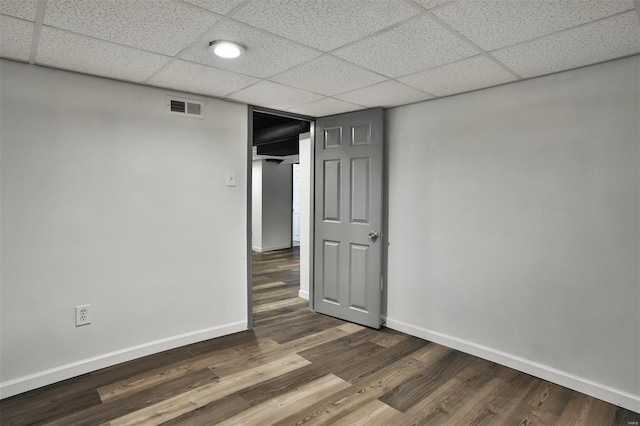 spare room featuring a paneled ceiling and wood-type flooring