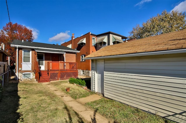 view of side of property with covered porch and a lawn