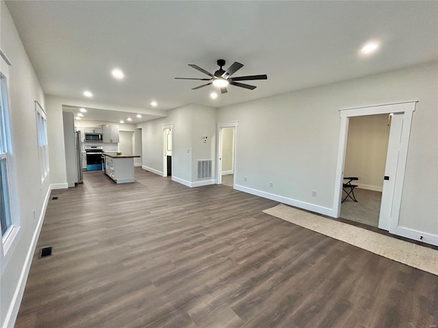 unfurnished living room featuring ceiling fan and dark hardwood / wood-style floors