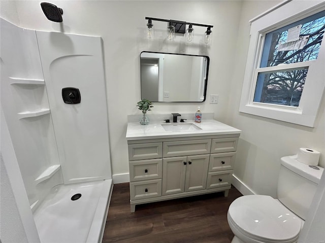 bathroom featuring hardwood / wood-style flooring, vanity, toilet, and walk in shower