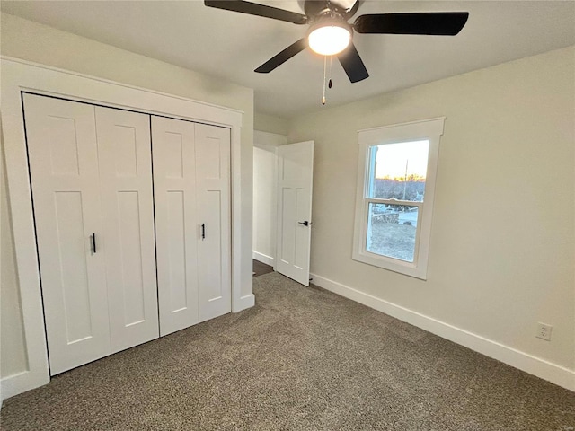 unfurnished bedroom with dark carpet, a closet, and ceiling fan