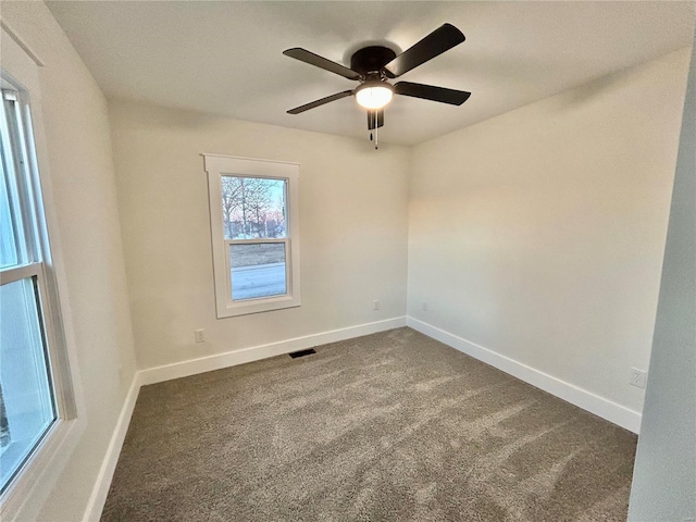 carpeted spare room featuring ceiling fan