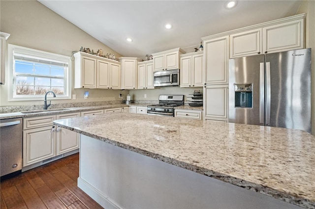 kitchen featuring lofted ceiling, sink, stainless steel appliances, light stone countertops, and dark hardwood / wood-style flooring