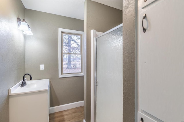 bathroom featuring vanity, an enclosed shower, and wood-type flooring