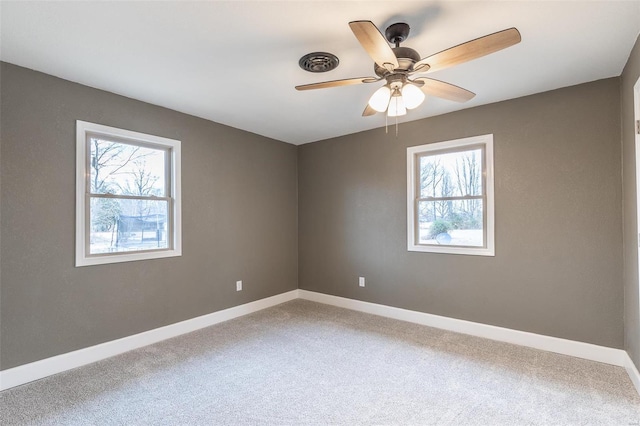 carpeted empty room featuring ceiling fan and a healthy amount of sunlight