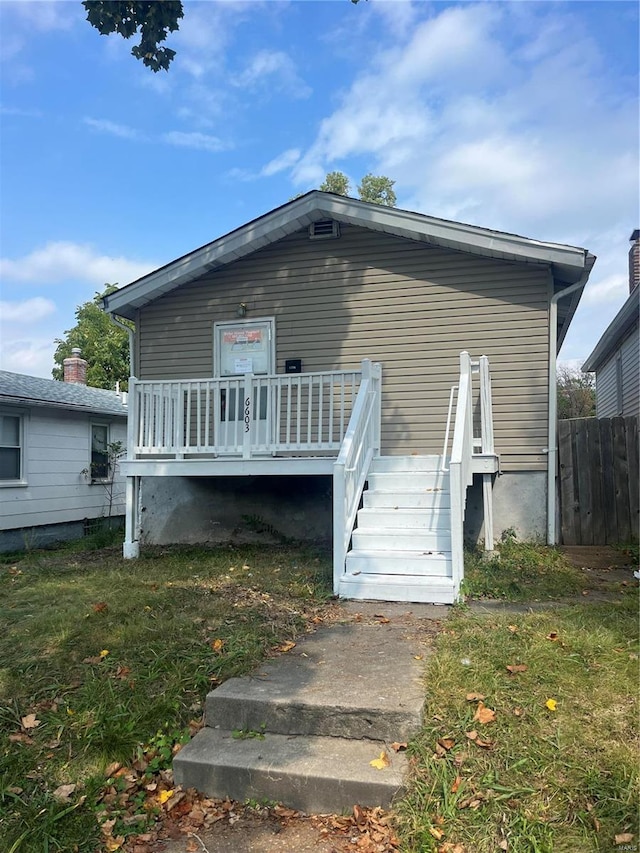 back of house with a wooden deck and a yard