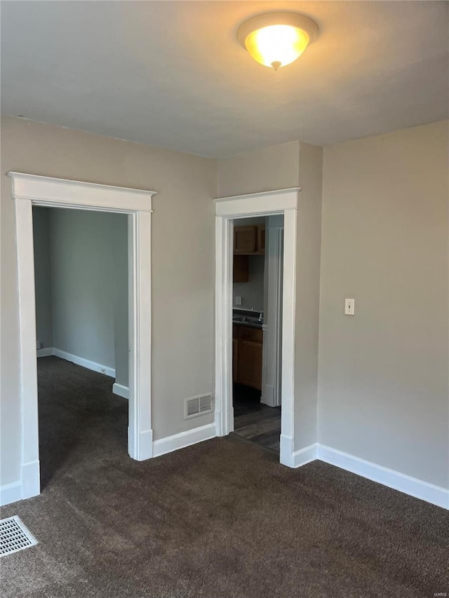 empty room featuring dark colored carpet